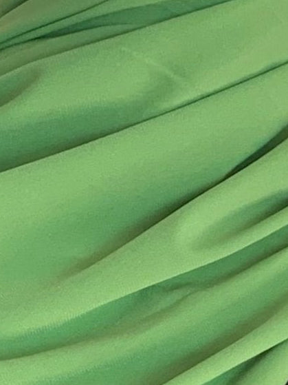 Hijab jersey vert pistache posé dans un parc, ambiance naturelle, tissu fluide et mat