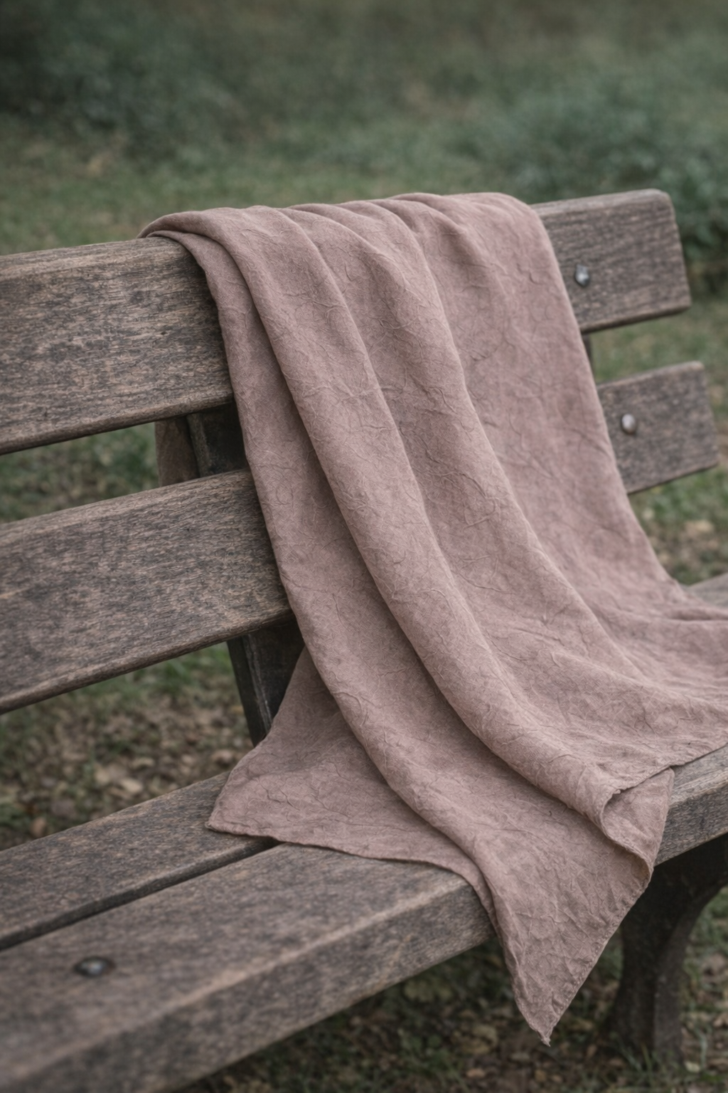 Hijab bambou taupe déposé sur un banc, décor naturel et minimaliste, ambiance chic et apaisante.

