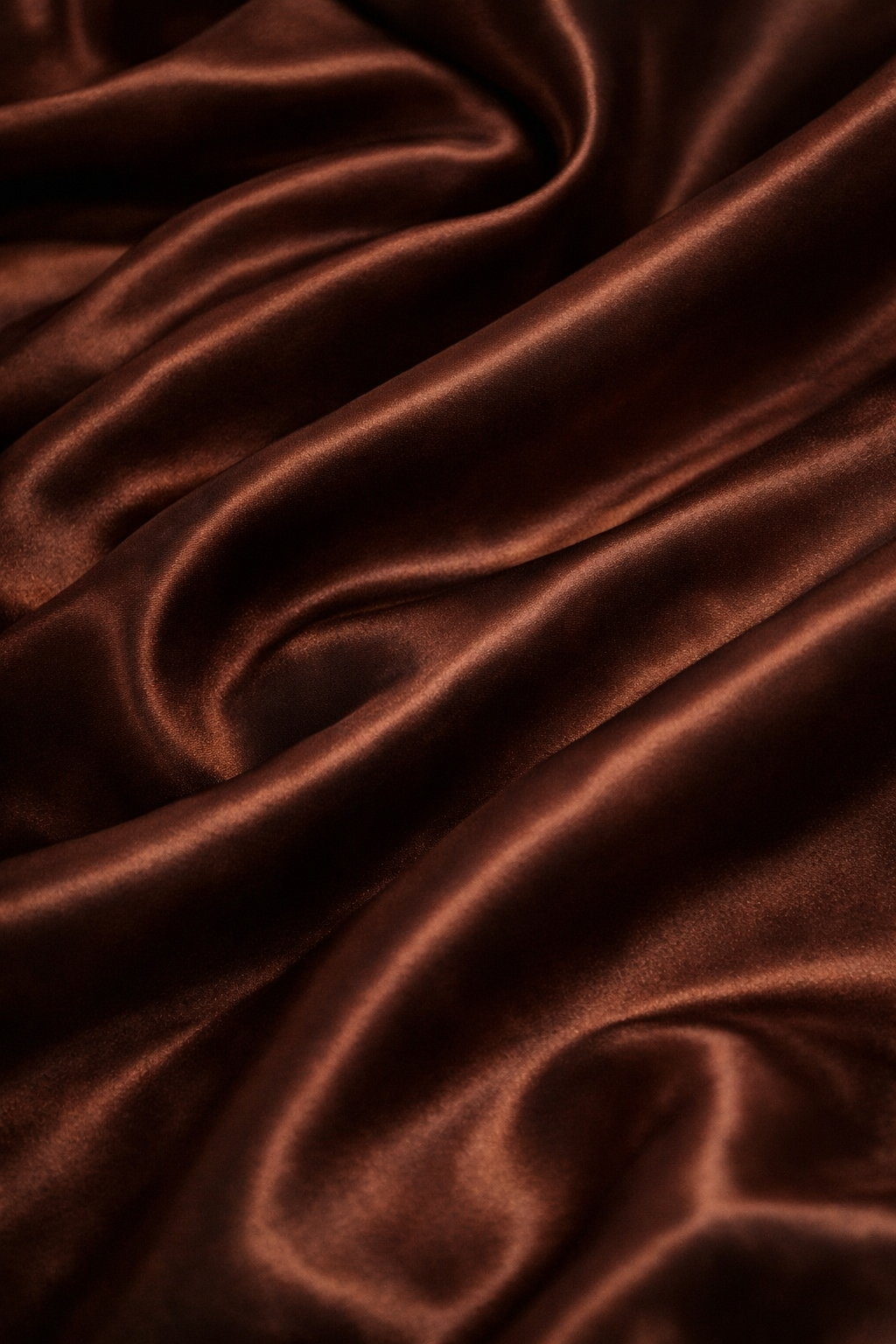 Gros plan du tissu satin chocolat montrant la brillance et la qualité premium